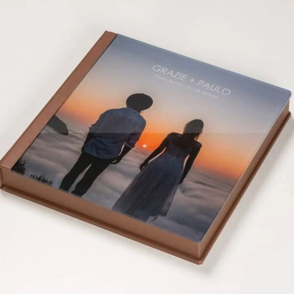 Caixa Acrilica Foto c Aba Paisagem de capa de álbum fotográfico com casal na praia ao pôr do sol, estilo amplo e artístico.