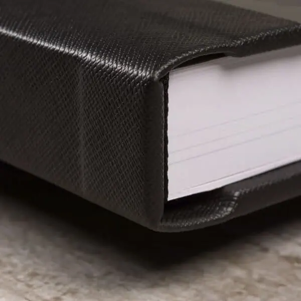 Alméria Caderno encadernado com capa resistente em couro sintético preto e páginas brancas.