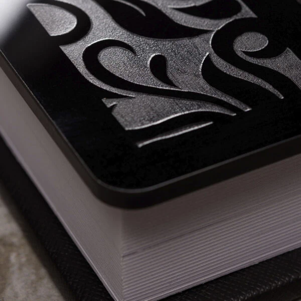 Alméria Livro de fotografia com capa texturizada preta e detalhes em relevo.