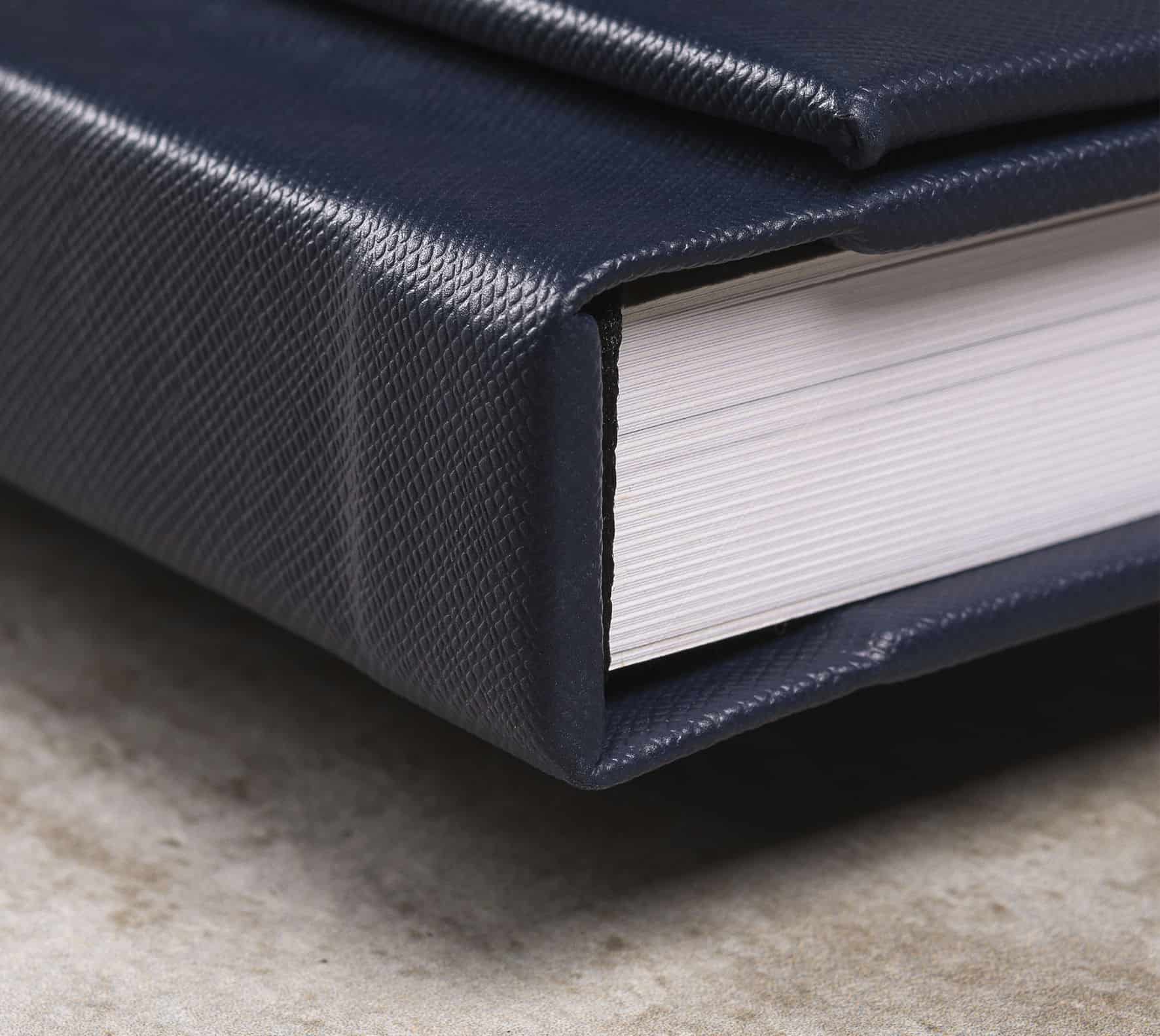 Capa dura de álbum de fotos com textura resistente, ideal para armazenamento de fotos e recordações.