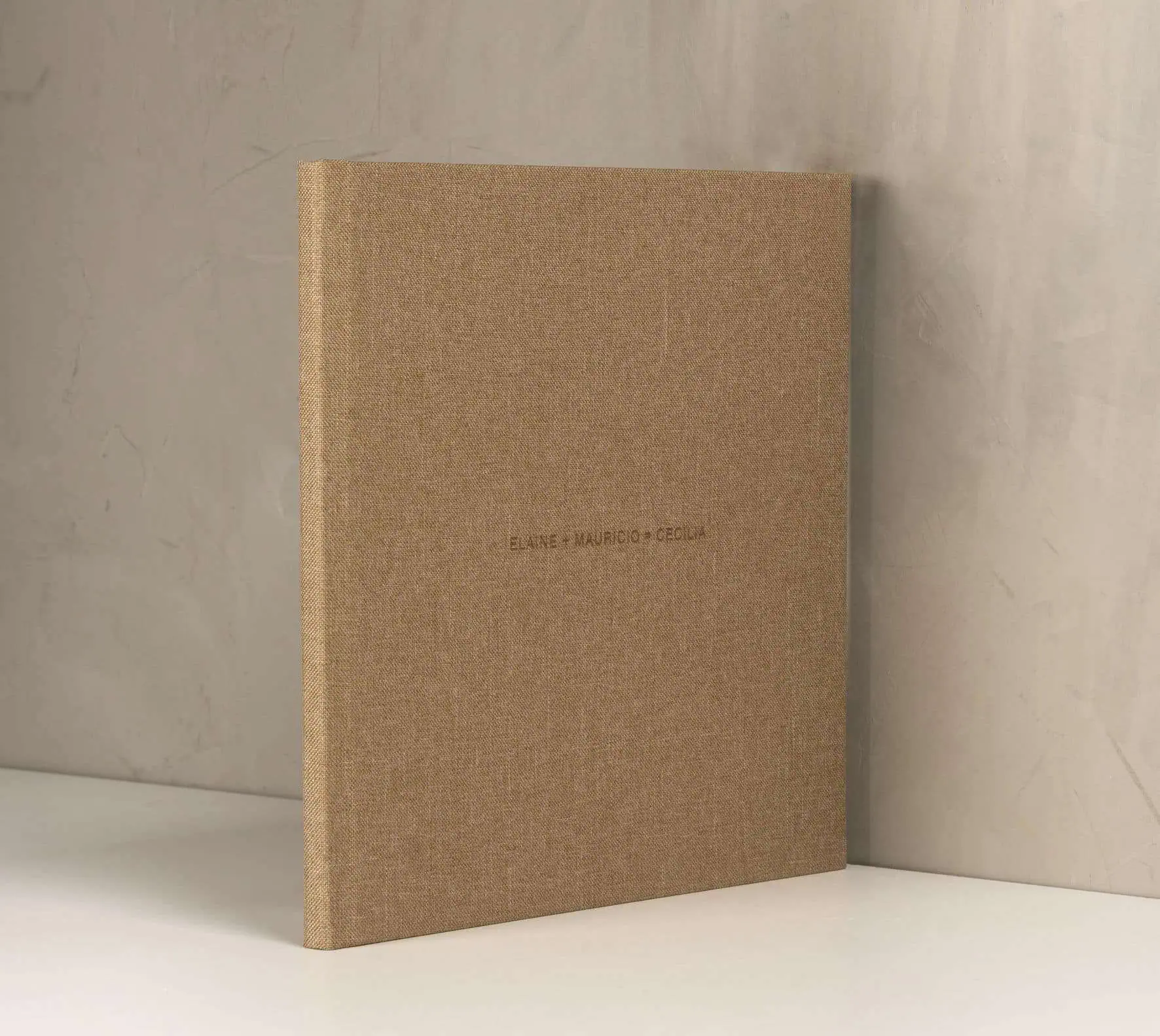 Álbum de fotos personalizado em tom natural com nomes escritos na capa.