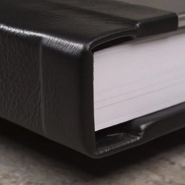 Caderno de fotos profissional com acabamento em couro preto.