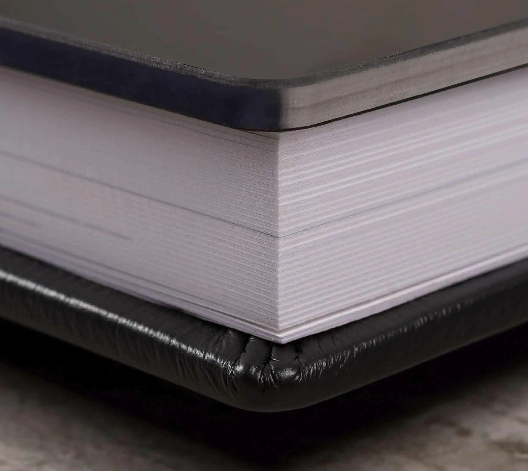 Arranjo de livros de fotografia com páginas brancas e capa preta para estúdio fotográfico.