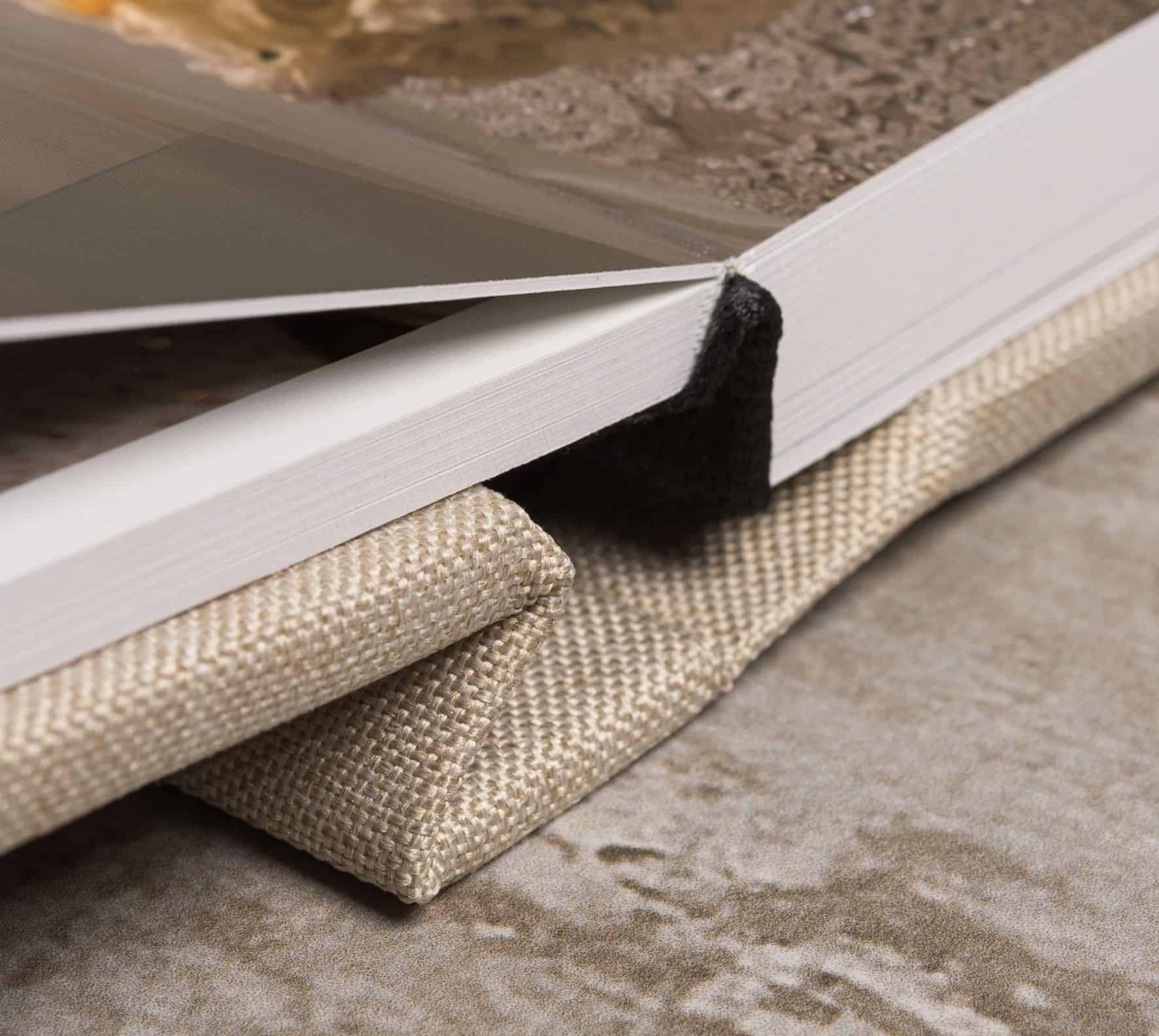 Livro de amostras de cores com capa de tecido e pĂĄginas brancas, em ambiente interno.