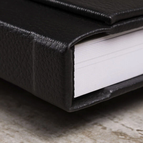 Janela com imã Livro com capa de couro preto e páginas brancas, ideal para colecionar fotos e lembranças.