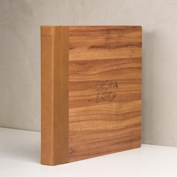 Linha Wood Caderno de capa de madeira com detalhes em dourado e inscrição artesanal.