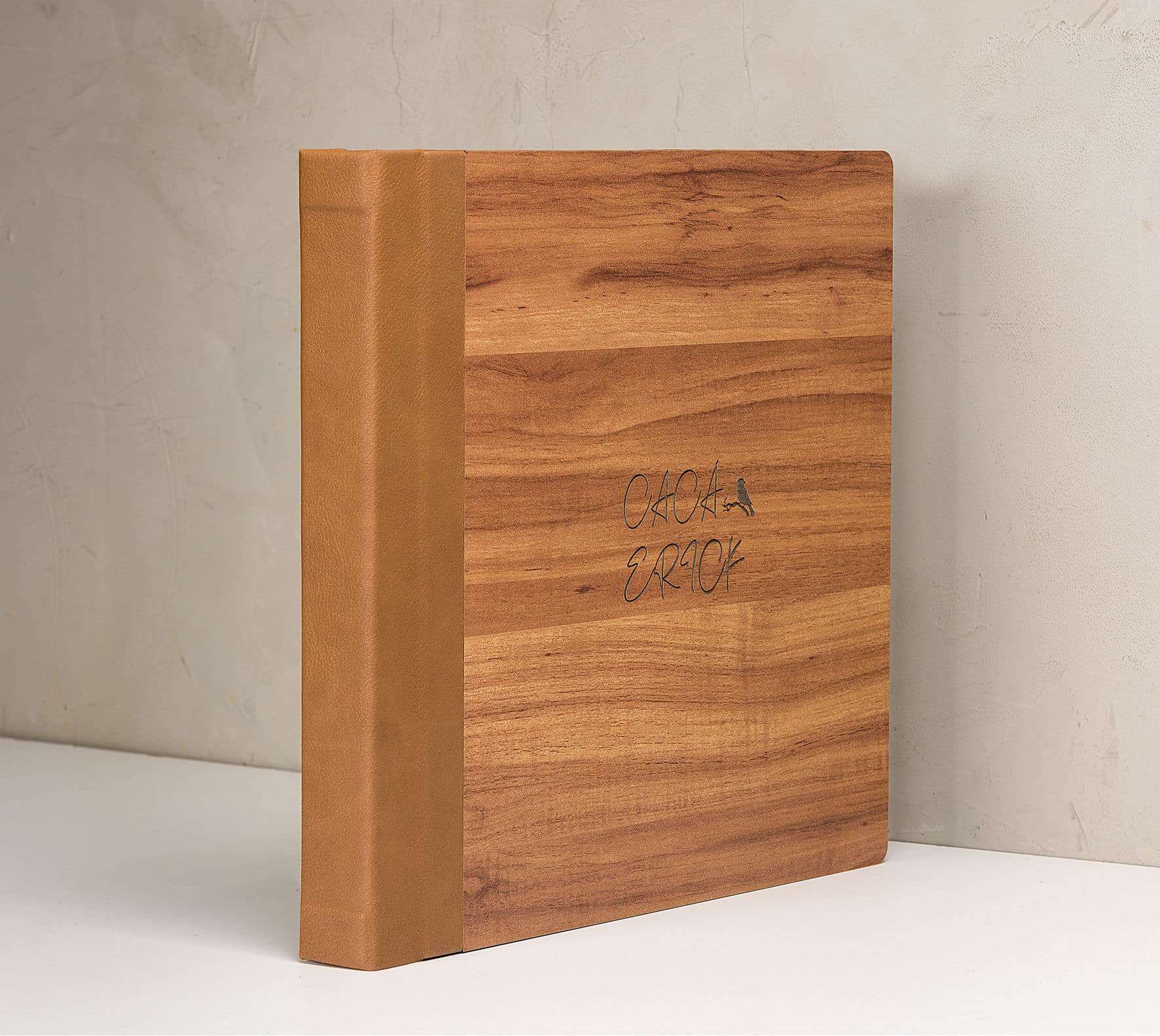 Caderno de capa de madeira com detalhes em dourado e inscrição artesanal.