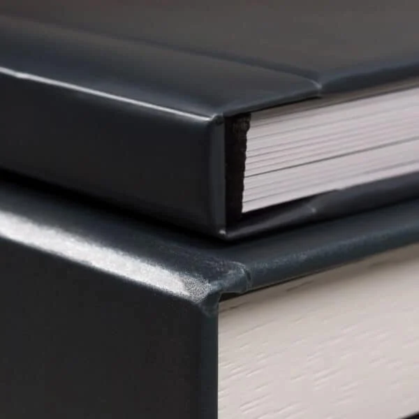 Livro antigo com capa de couro preto e páginas brancas em destaque no site Fotoclub.