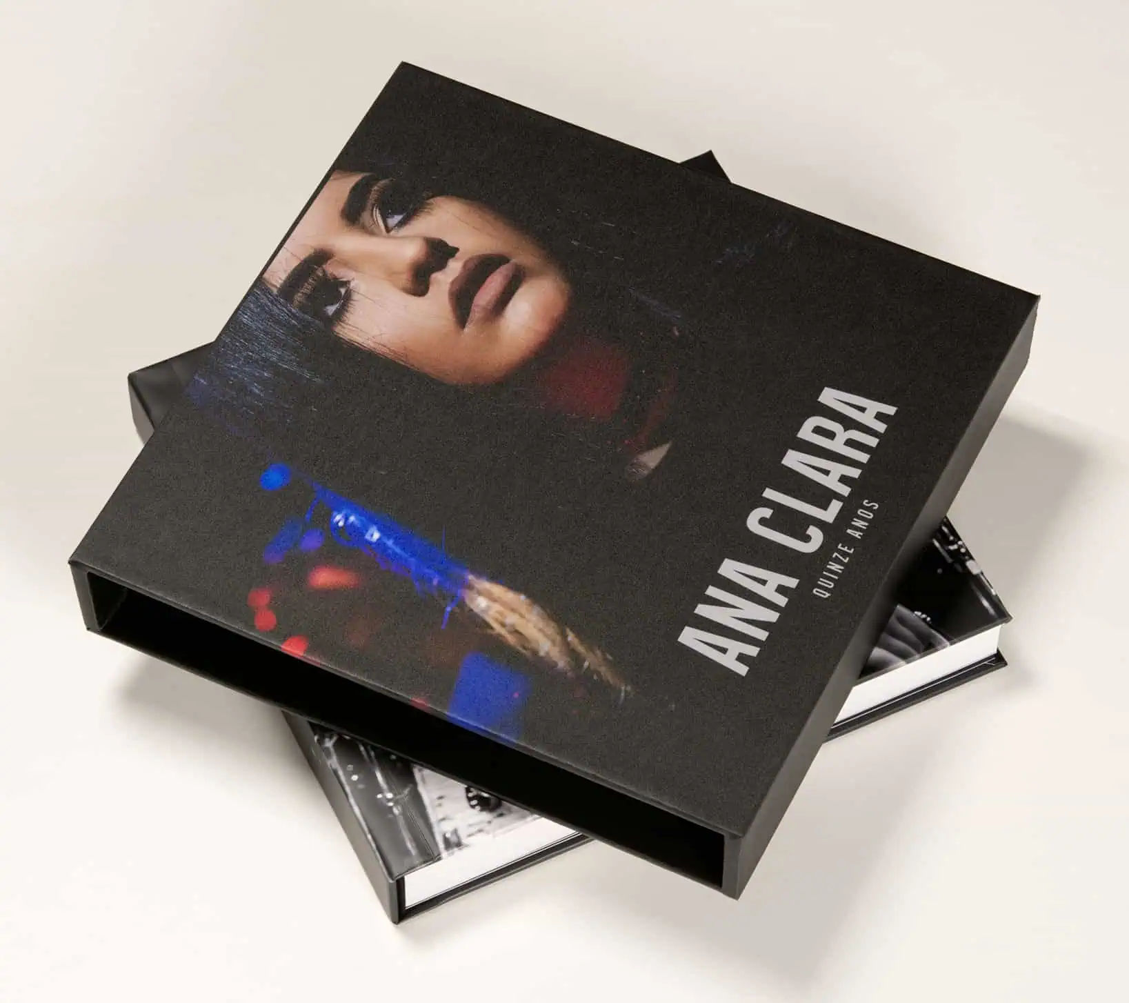 Mulher em livro de fotografia Anna Clária, celebra 15 anos de carreira, destaque em exposição de arte e moda.