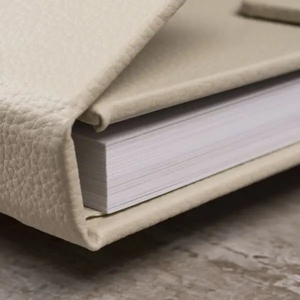 Memory Livro com capa de couro bege, foco em fotografia, arte e cultura.