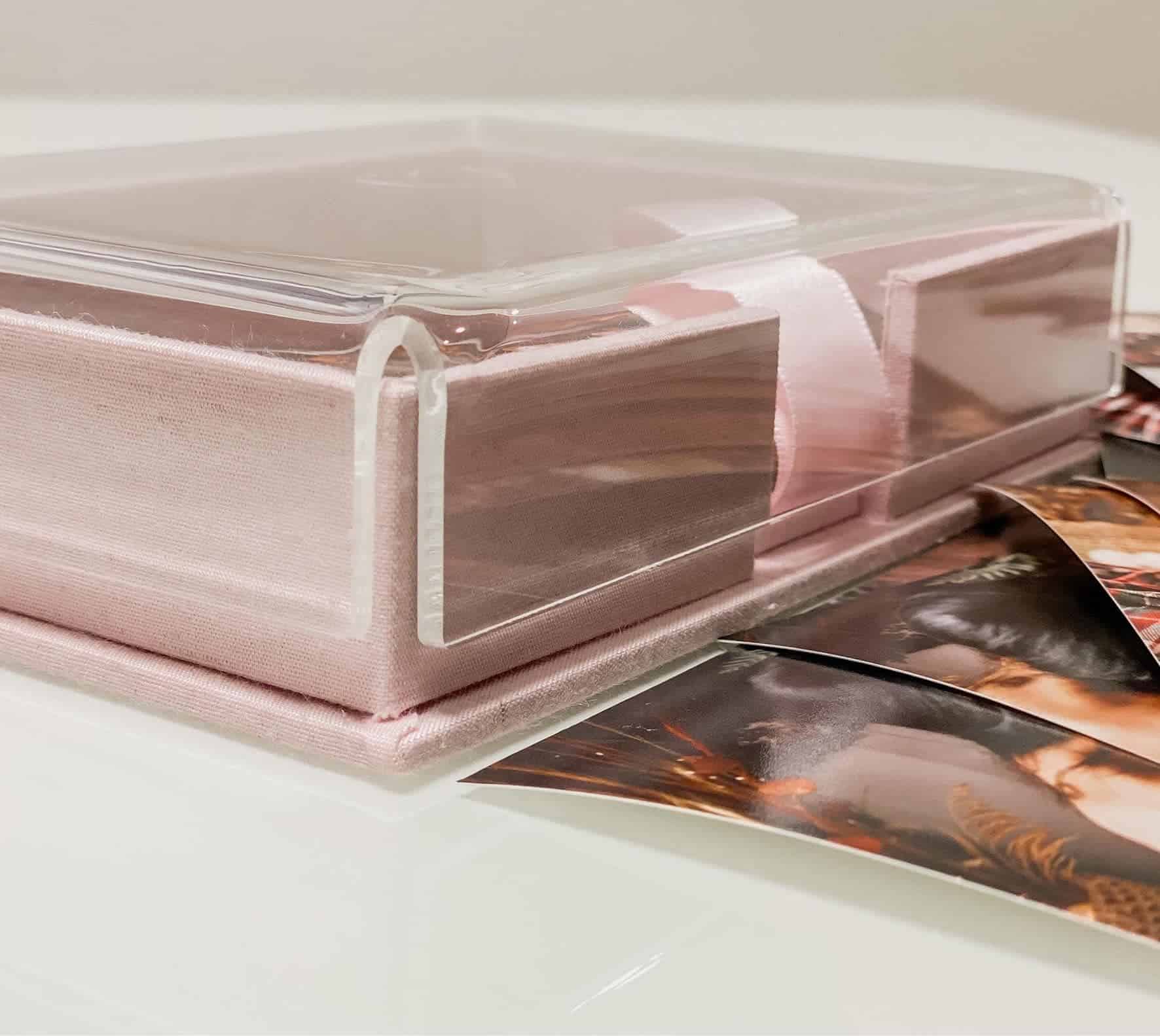 Álbum fotográfico em embalagem rosa com fotos de paisagens ao redor.