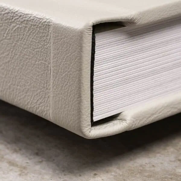 Coleção de livros fotográficos com capa de couro cremosa, destacando a qualidade de impressão e acabamento premium.