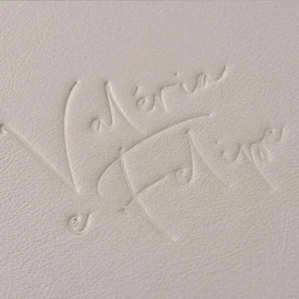 Detalhe de relevo com assinatura elegante em papel texturizado.