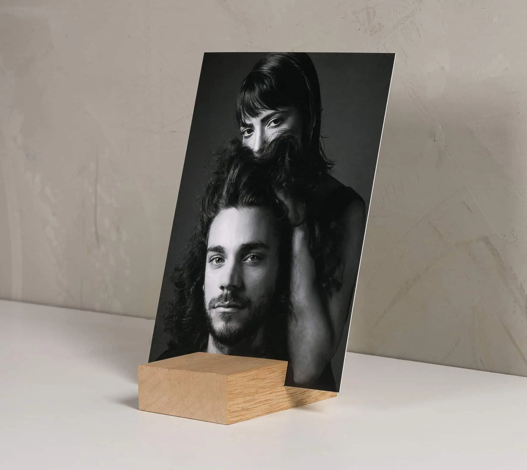 Detalhe de quadro de fotografia em preto e branco com base de madeira, destacando arte fotográfica e decoração.