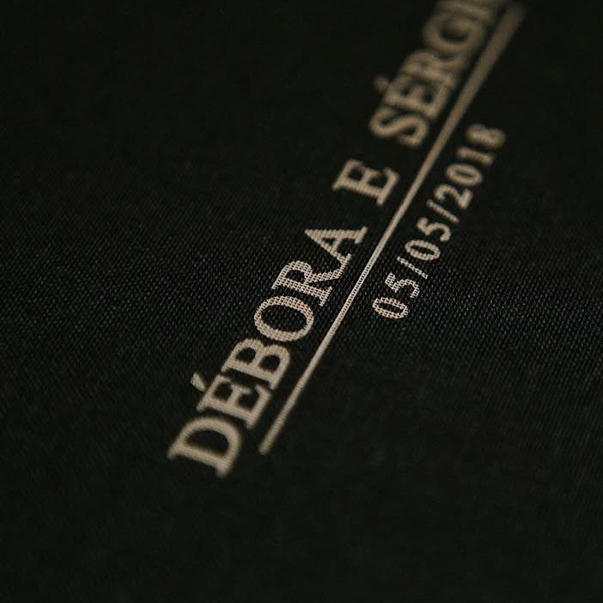 Apenas uma imagem de um caderno com a palavra "DEBORA" e a data "05/05/2016" impressas na capa, em f.