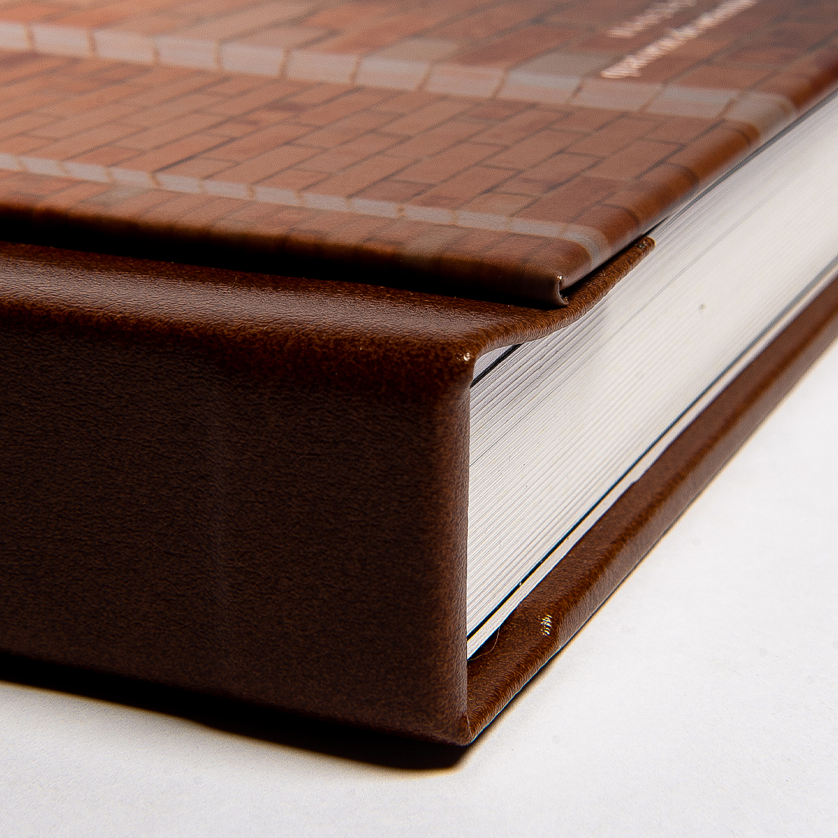 Álbum de fotos com capa de couro e páginas brancas, destaque para detalhes de acabamento e textura.