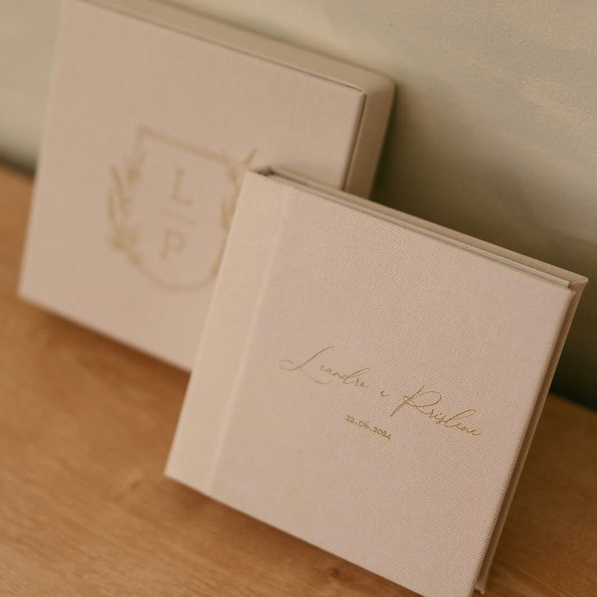 Álbum de fotos de casamento com capa branca elegante e detalhes dourados.