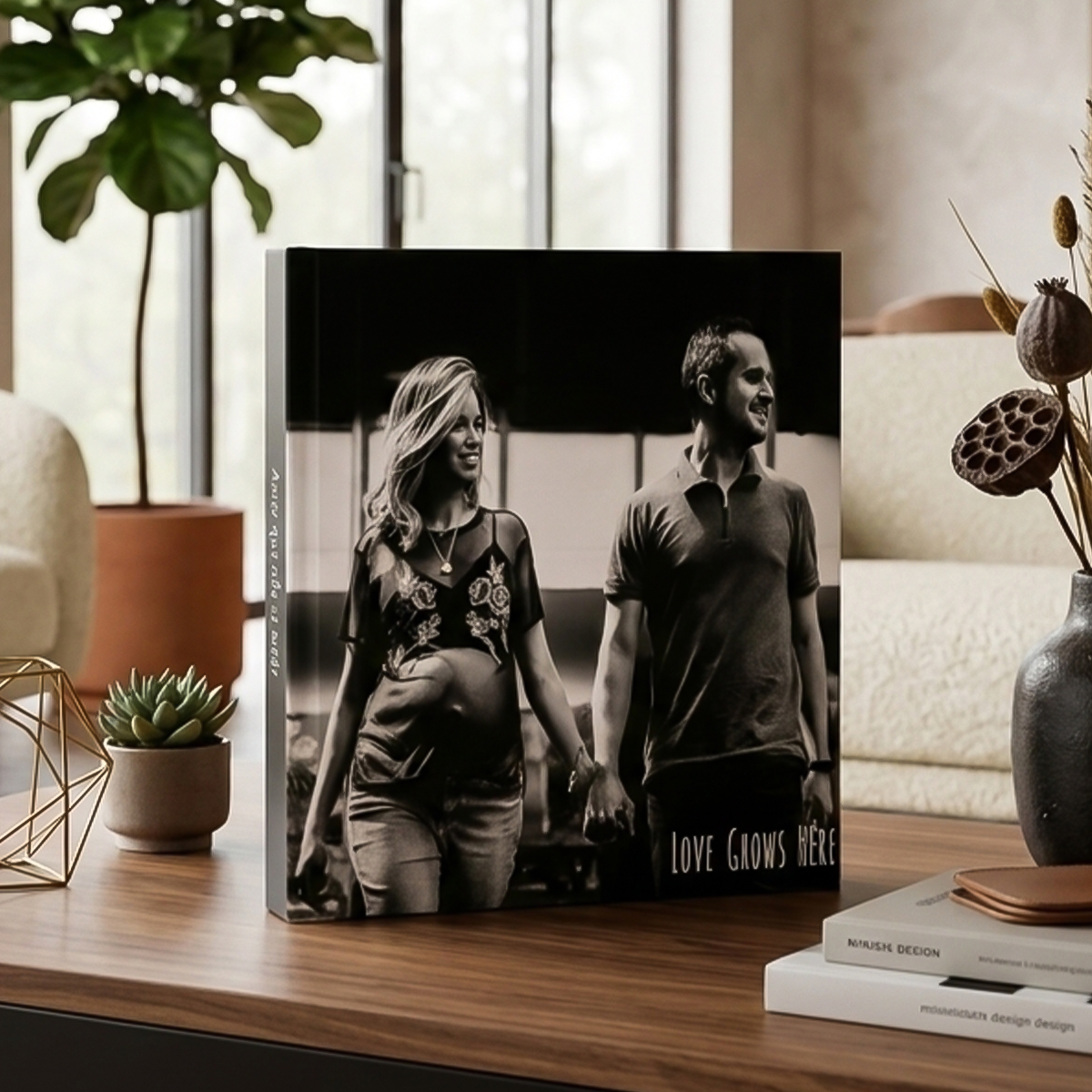 Livro de fotos com casal na capa, decoração moderna e natural ao redor.