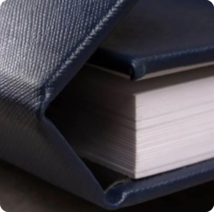 Livro de fotografia com capa azul escura e páginas brancas.
