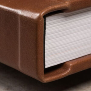Livro de fotos com capa de couro marrom e páginas brancas.