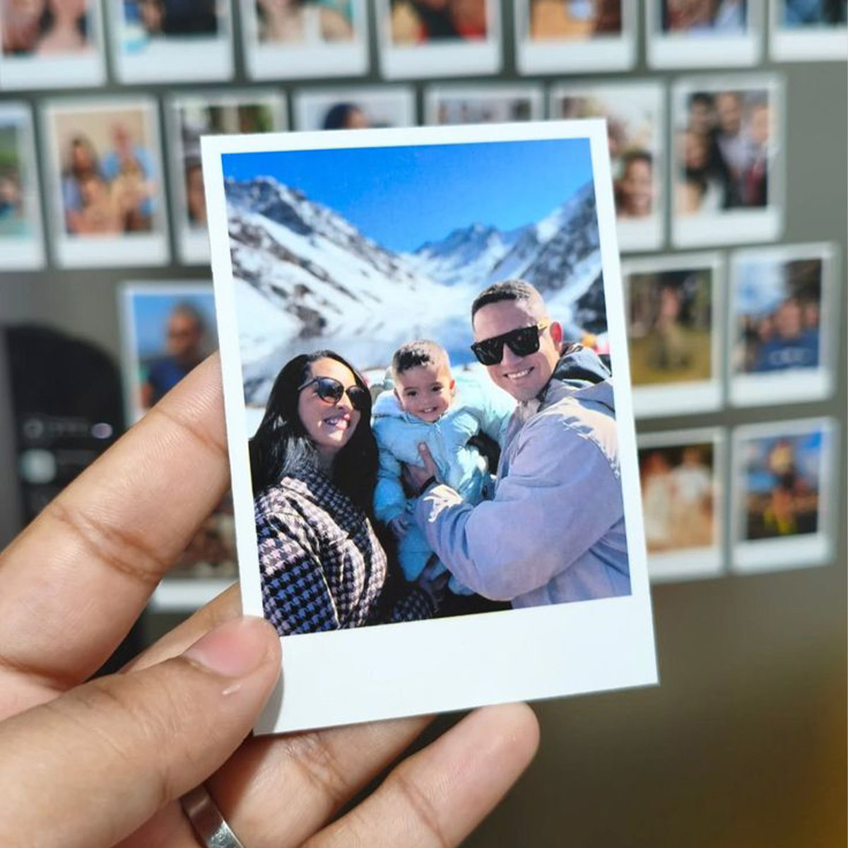 Família sorridente em paisagem de montanha com neve ao fundo.