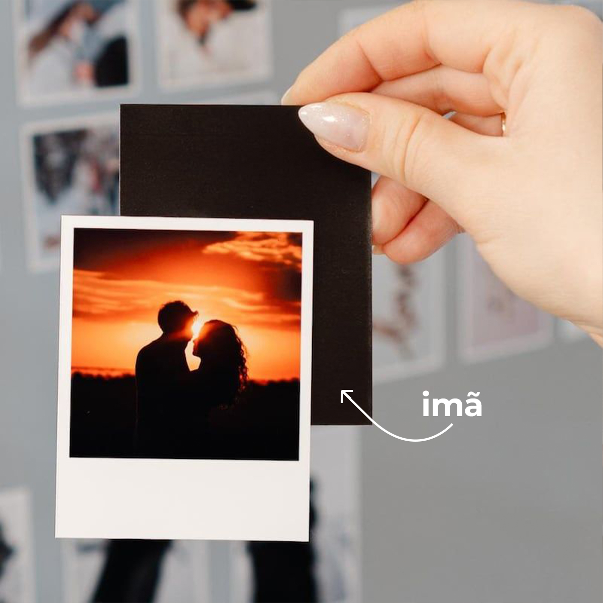 Fotografia de um pôr do sol com casal em silhueta segurando uma foto instantânea.